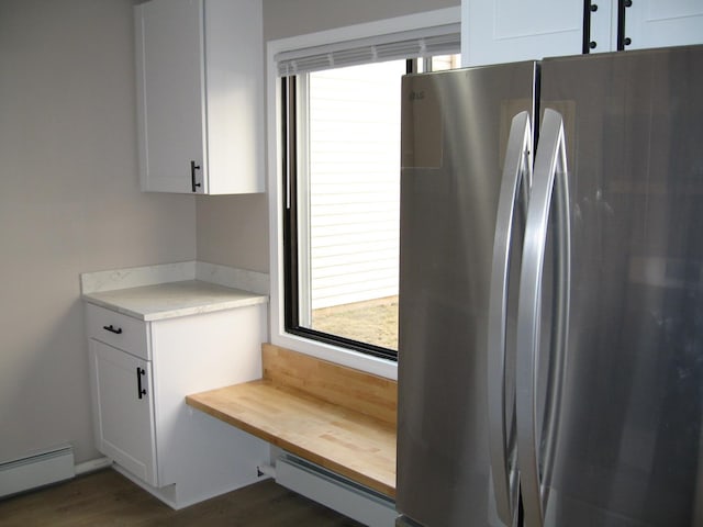 kitchen featuring white cabinetry, wood counters, a baseboard heating unit, and freestanding refrigerator