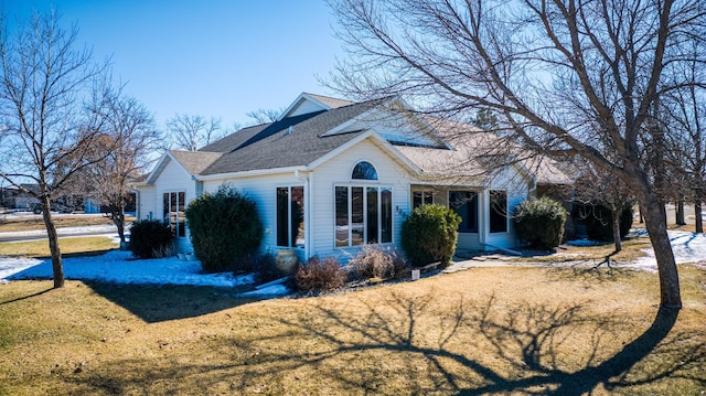 view of front facade featuring a front lawn and a shingled roof