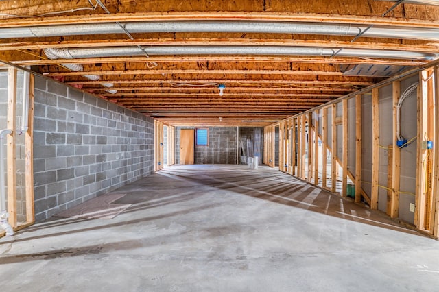 unfinished basement featuring concrete block wall