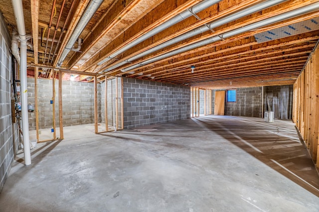 unfinished below grade area featuring concrete block wall