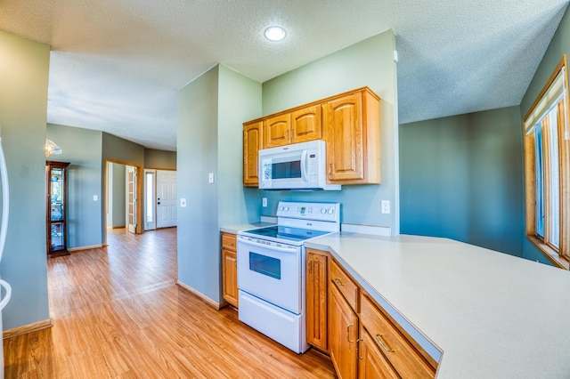 kitchen featuring white appliances, light wood finished floors, baseboards, light countertops, and a textured ceiling