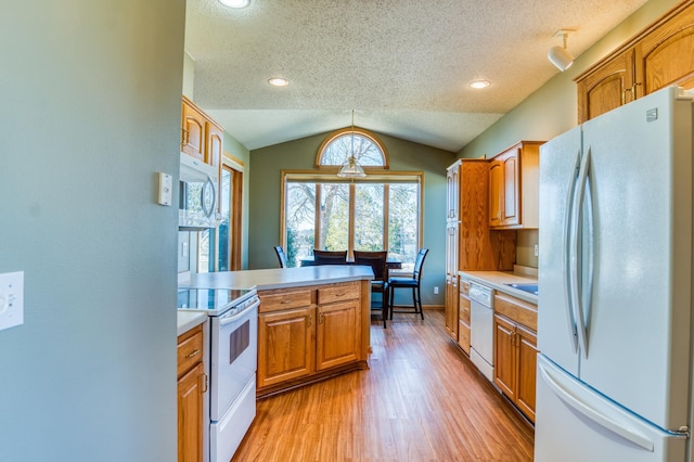 kitchen with white appliances, brown cabinetry, lofted ceiling, light countertops, and light wood-type flooring