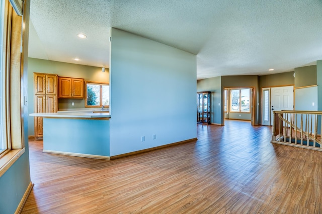 kitchen featuring baseboards, a healthy amount of sunlight, and light wood-style floors