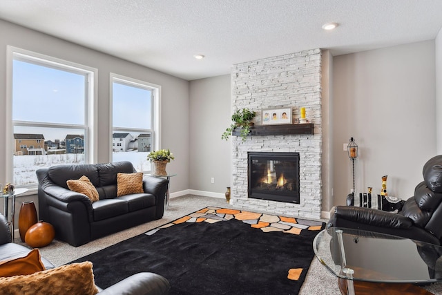 carpeted living room with a textured ceiling, a fireplace, and baseboards