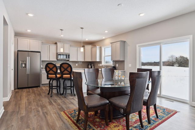 dining space with baseboards, dark wood-type flooring, and recessed lighting