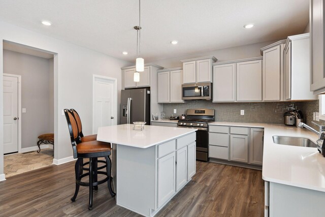 kitchen featuring tasteful backsplash, appliances with stainless steel finishes, a sink, and a center island