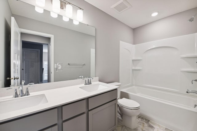 full bathroom featuring toilet, marble finish floor, visible vents, and a sink