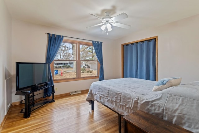 bedroom with light wood finished floors, ceiling fan, and baseboards