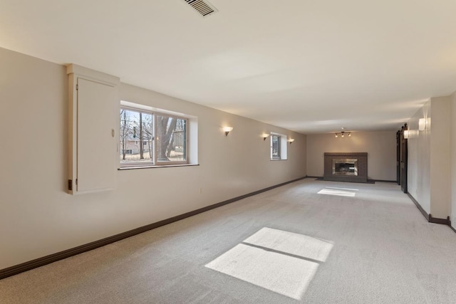 unfurnished living room featuring light carpet, a brick fireplace, visible vents, and baseboards