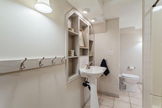 bathroom featuring tile patterned flooring, toilet, and baseboards