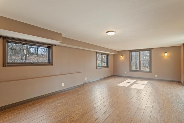 spare room featuring light wood-type flooring and baseboards