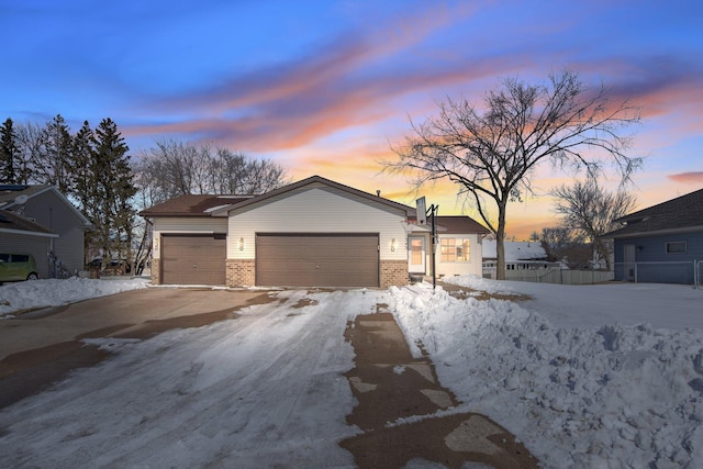 view of front of home featuring a garage, fence, and brick siding