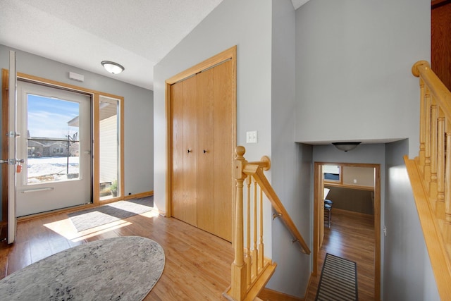 foyer featuring light wood finished floors and a textured ceiling