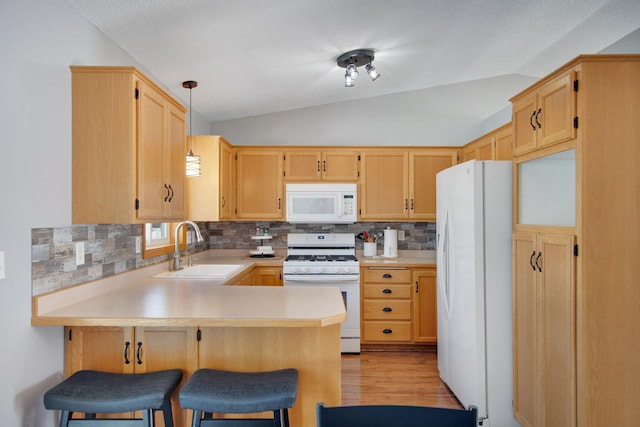 kitchen with vaulted ceiling, decorative backsplash, a peninsula, white appliances, and a sink