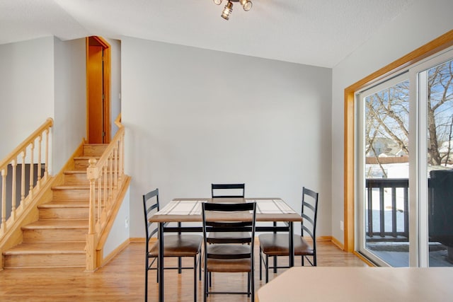 dining area with a healthy amount of sunlight, light wood-style flooring, and baseboards