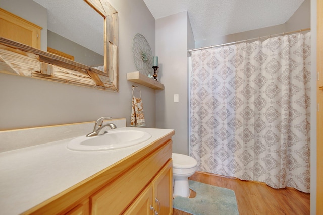 bathroom with vanity, wood finished floors, a textured ceiling, curtained shower, and toilet