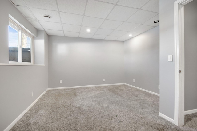 below grade area featuring carpet flooring, recessed lighting, baseboards, and a drop ceiling