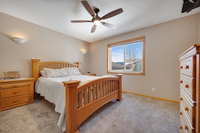 bedroom with carpet flooring, a textured ceiling, baseboards, and a ceiling fan