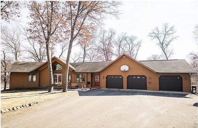 rustic home with driveway and a garage