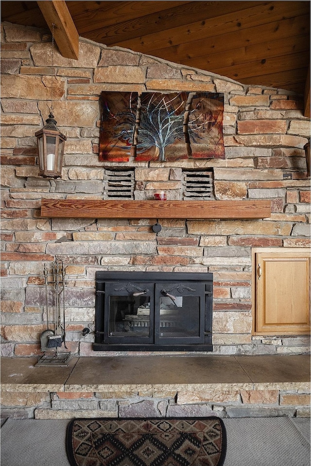 details featuring beam ceiling and a stone fireplace