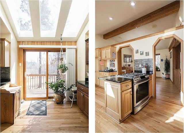 kitchen featuring stainless steel gas stove, decorative backsplash, dark countertops, lofted ceiling with skylight, and light wood-type flooring