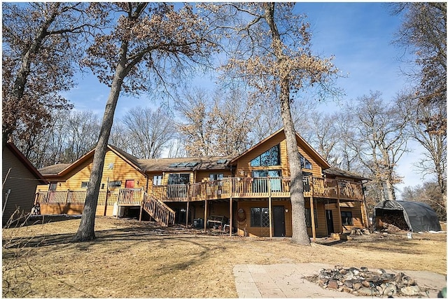 back of property with a deck and stairs