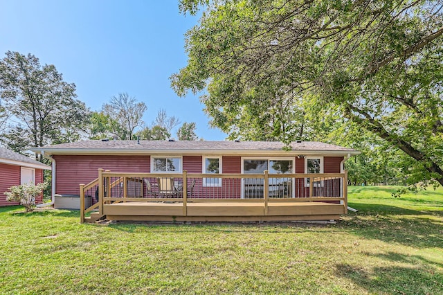 rear view of house with a deck and a yard