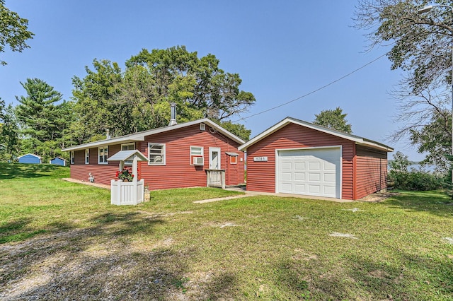 ranch-style home with cooling unit, a garage, an outdoor structure, driveway, and a front yard