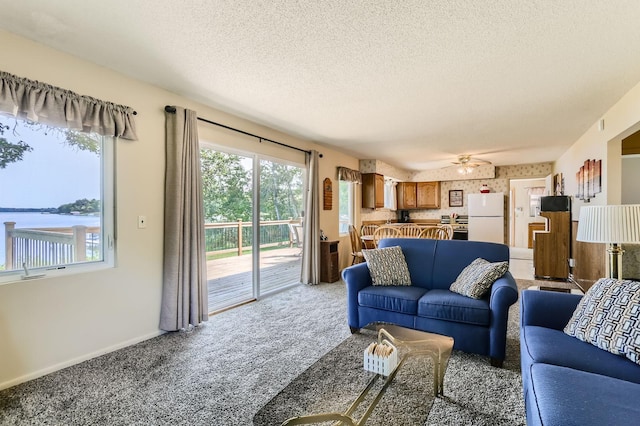 living area with wallpapered walls, baseboards, a textured ceiling, and light colored carpet