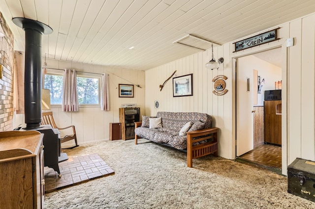 living room with a wood stove and wood ceiling