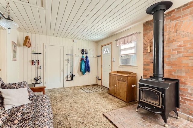 interior space featuring a wood stove, wooden ceiling, cooling unit, and light colored carpet