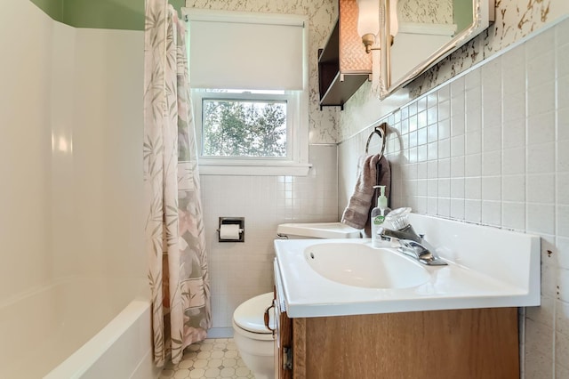 bathroom featuring toilet, wallpapered walls, and tile walls