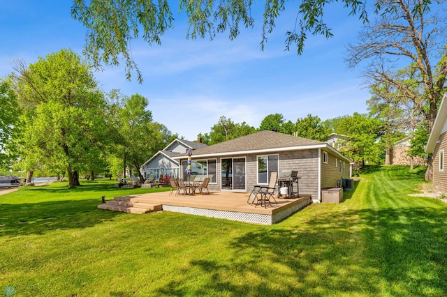 rear view of property featuring cooling unit, roof with shingles, a yard, and a wooden deck