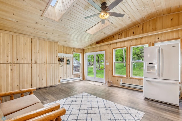 interior space with ceiling fan, lofted ceiling with skylight, baseboard heating, and wooden ceiling