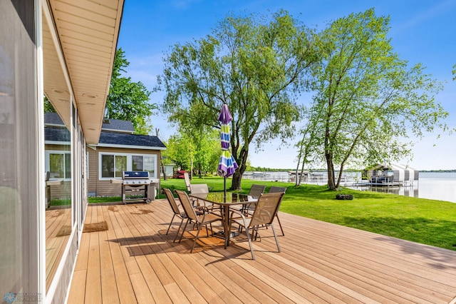 wooden terrace featuring a water view, grilling area, and a lawn