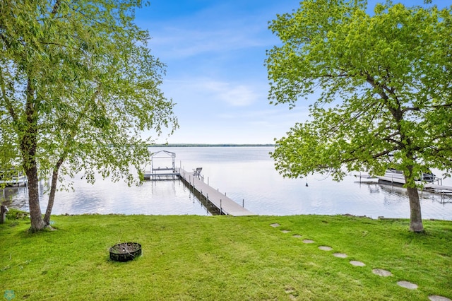 view of dock with a lawn, a water view, and boat lift