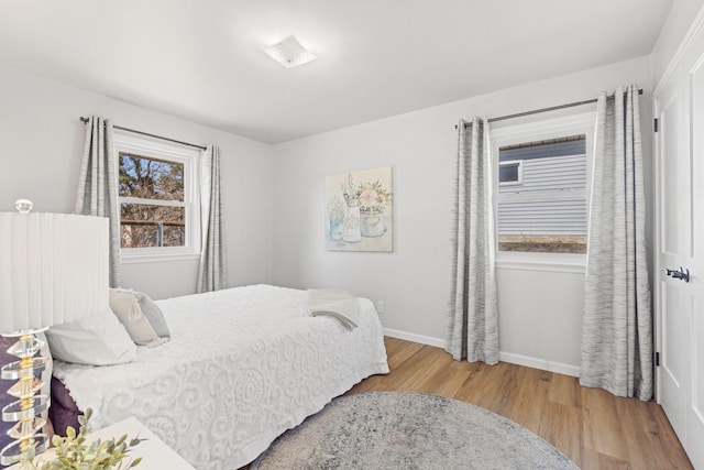 bedroom with baseboards and wood finished floors