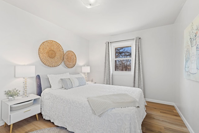 bedroom with wood finished floors and baseboards