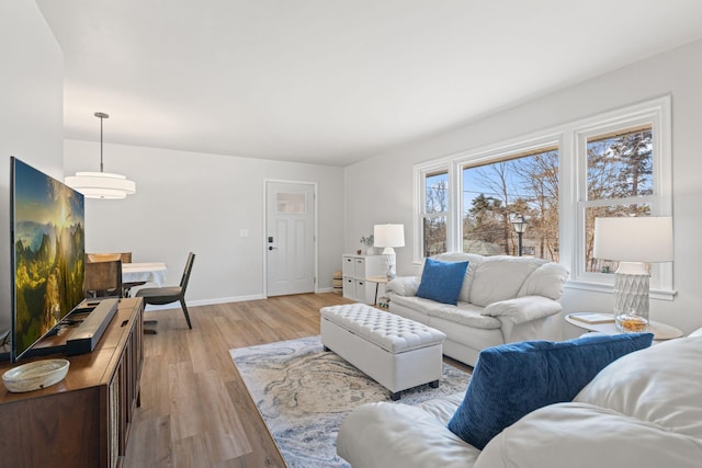 living room featuring light wood-type flooring and baseboards