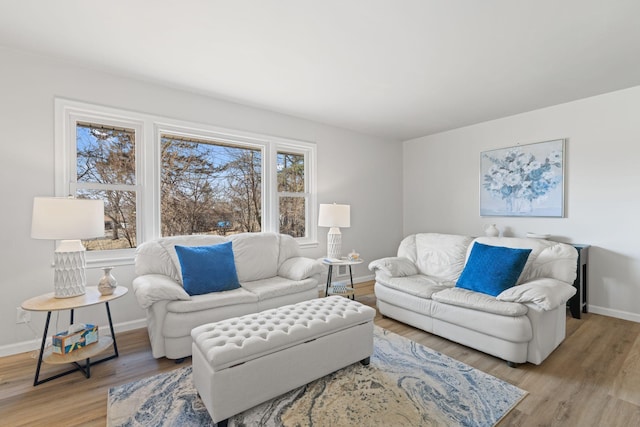 living area with baseboards and light wood finished floors