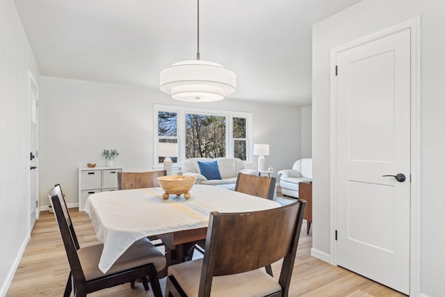 dining area with light wood-style flooring and baseboards