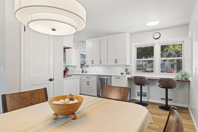 dining space featuring baseboards, plenty of natural light, and light wood finished floors