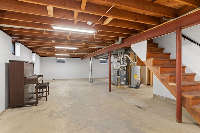 basement featuring gas water heater, stairway, and heating unit