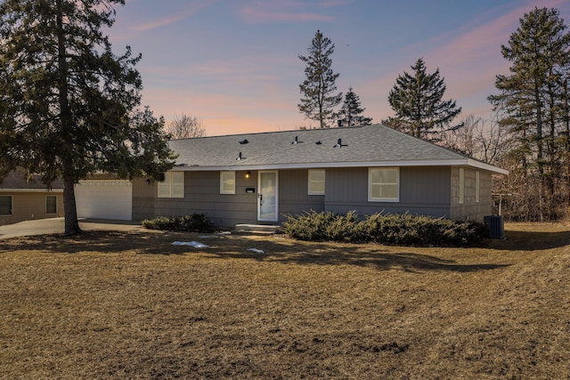 ranch-style home featuring driveway, a front yard, and roof with shingles