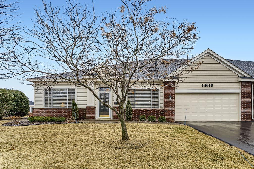 ranch-style house with an attached garage, driveway, a front lawn, and brick siding