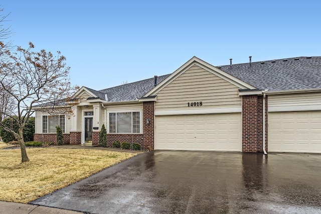 view of front of house featuring a garage, a front yard, and brick siding