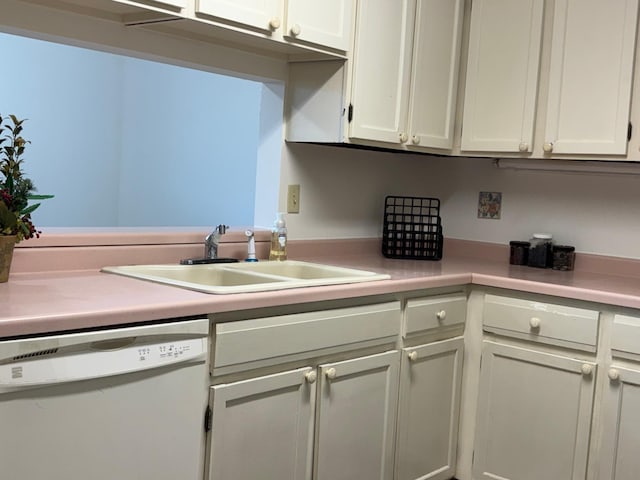 kitchen featuring dishwasher, light countertops, white cabinets, and a sink