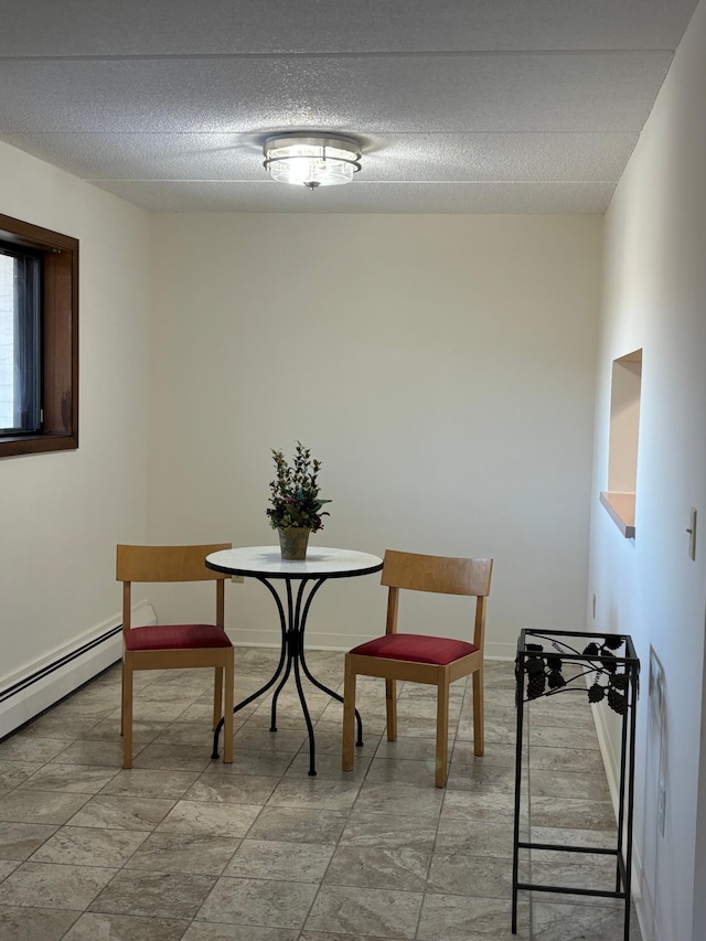 dining room featuring baseboards, baseboard heating, and a textured ceiling