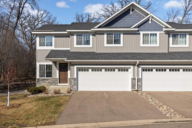 craftsman-style house featuring an attached garage, stone siding, driveway, and board and batten siding