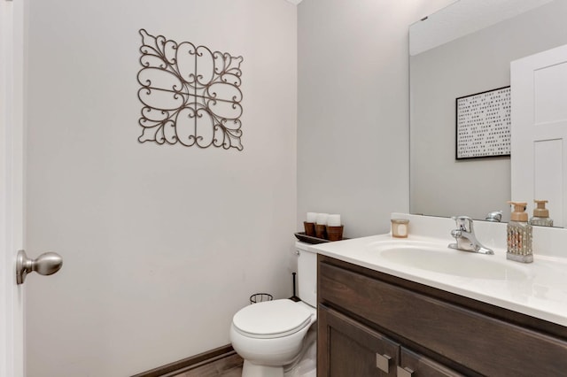 half bathroom with vanity and toilet